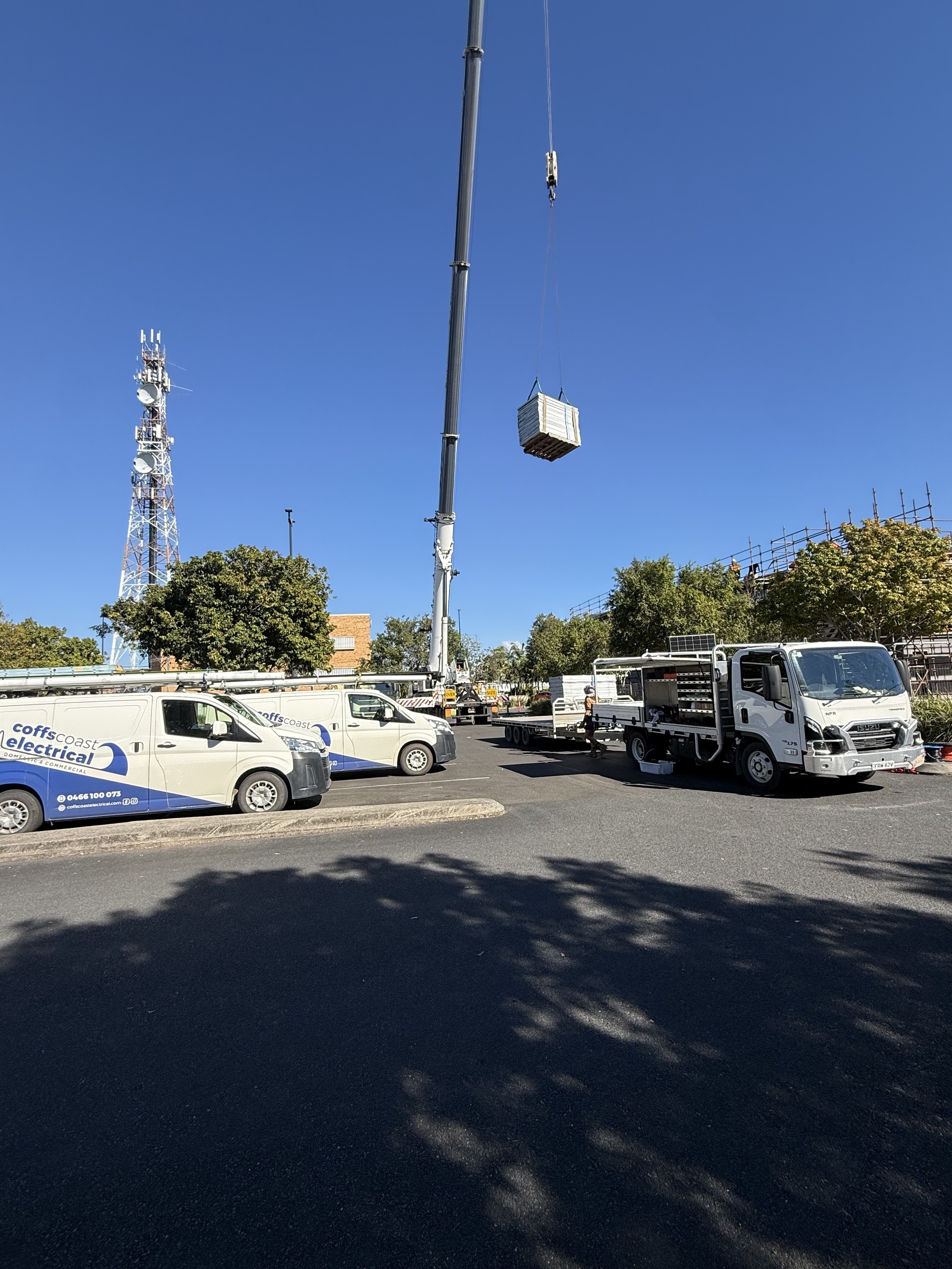 Coffs Coast Electrical vans and a crane lifting panels onto the Grafton Library roof