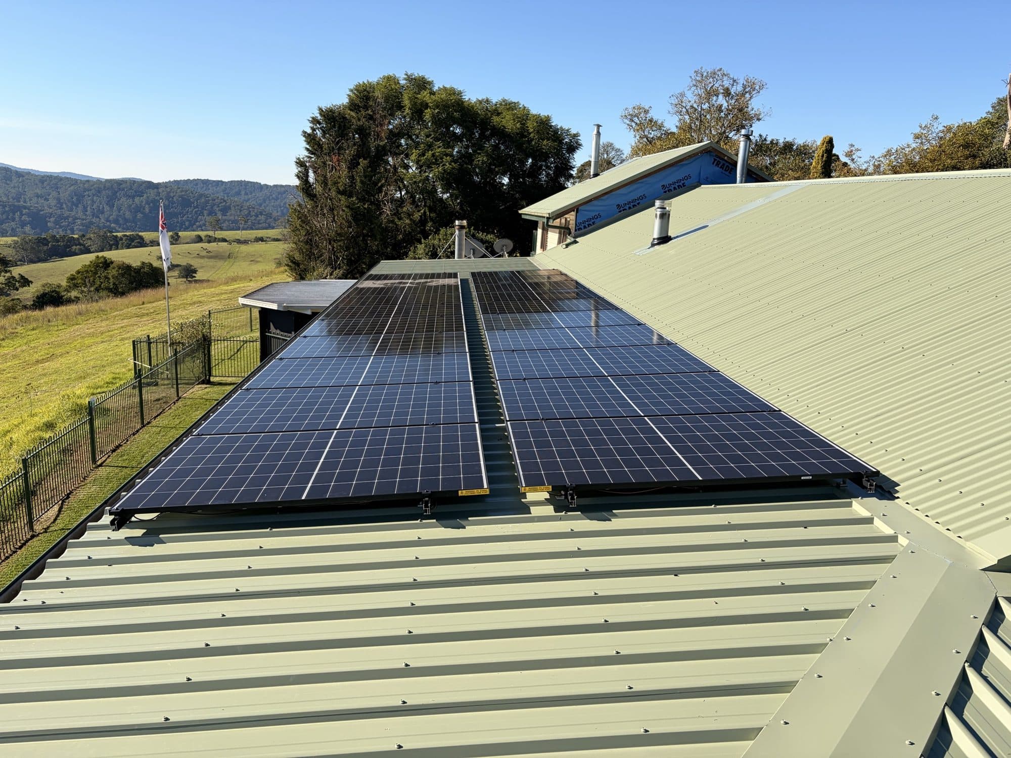 Jinko panels on a pale-green Colorbond roof with paddocks behind, Bonville