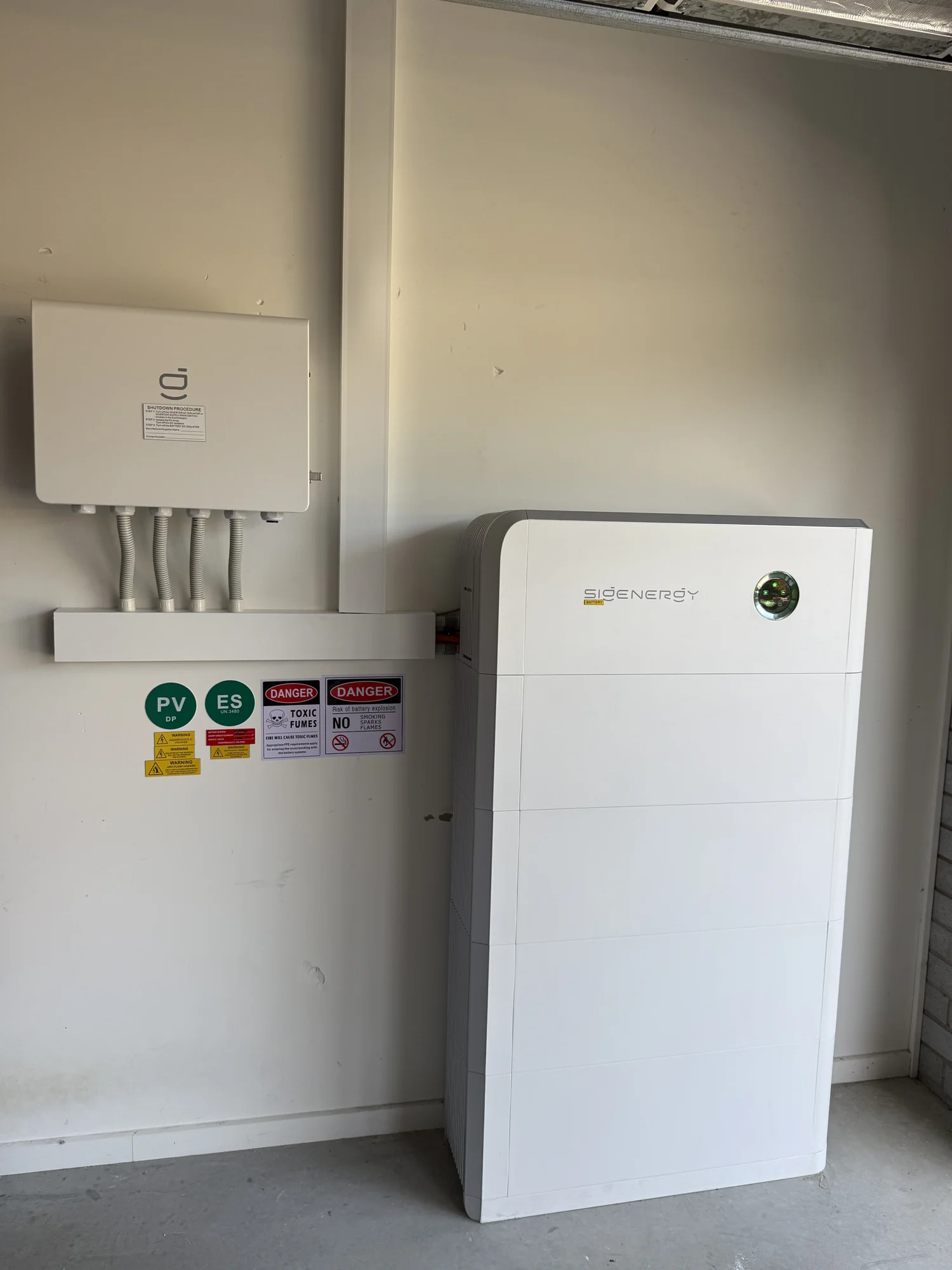 Home battery and inverter on a garage wall
